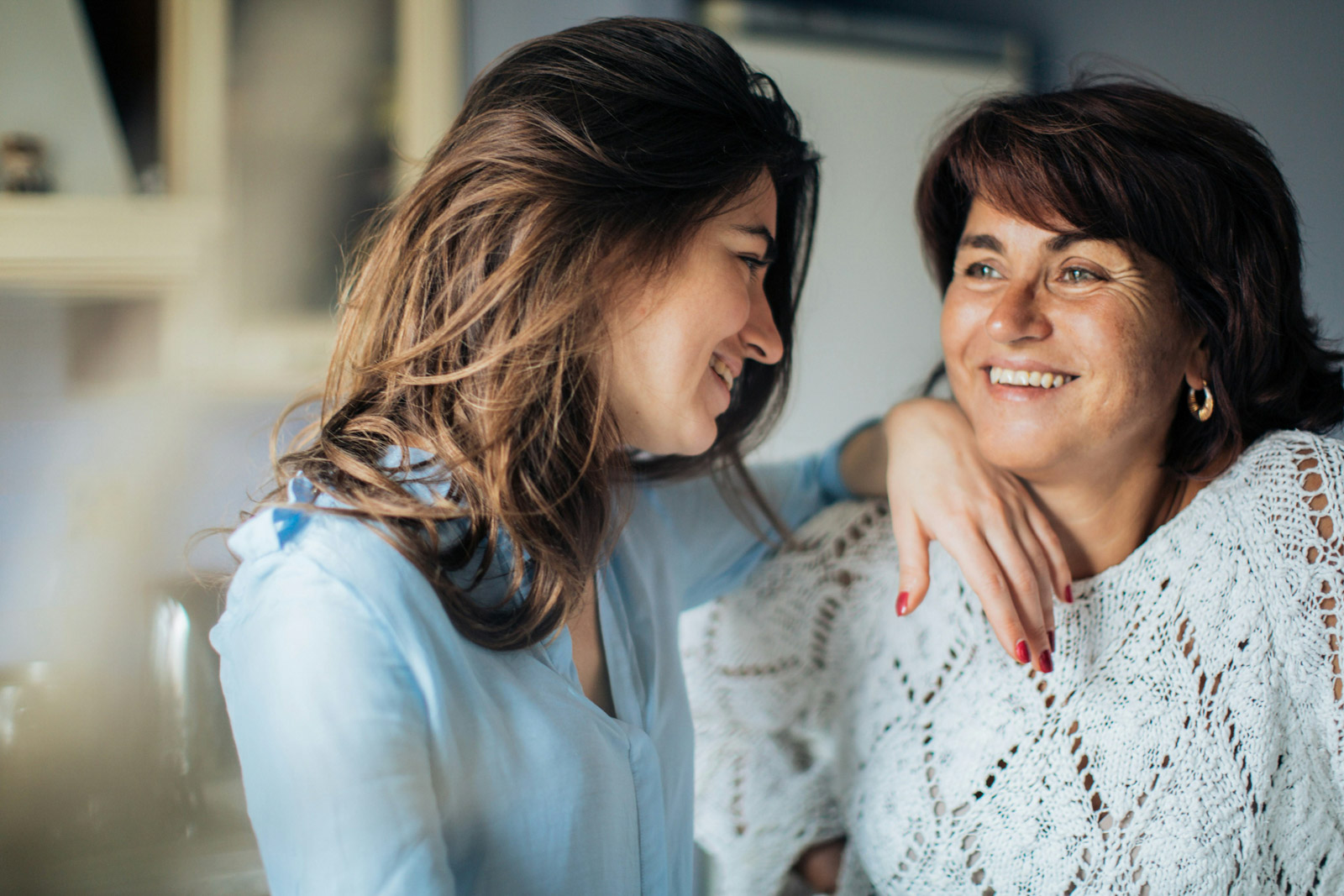 A mother and her teenage daughter laughing together